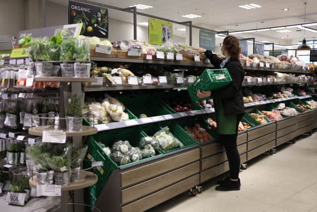 An employee stacks shelves at a Waitrose supermarket.