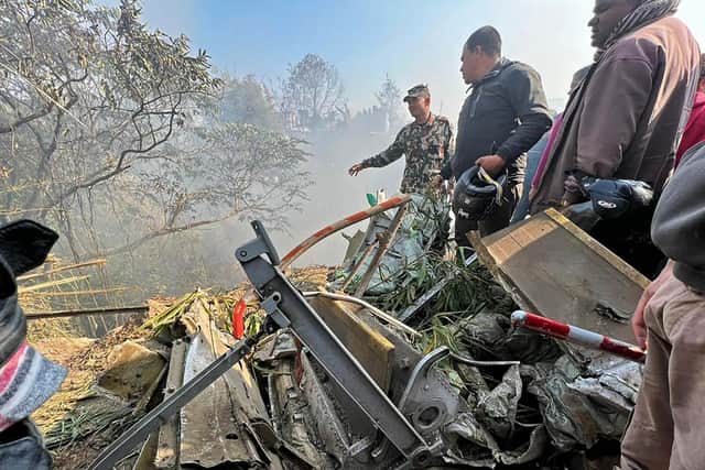 Rescuers gather at the site of a plane crash in Pokhara after an airplane crashed with 72 people on board in Nepal