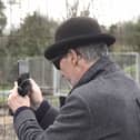A mystery man in a bowler hat has been seen scoping out a famous site where the illusive artist Banksy left a mural that was inadvertently torn down by builders