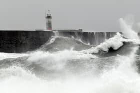 Waves crash over the breakwater by Newhaven Lighthouse as Storm Barra passes through Newhaven, southern England on December 7, 2021. (Photo by GLYN KIRK / AFP) (Photo by GLYN KIRK/AFP via Getty Images)