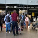 People queue for a lift at Heathrow Airport.