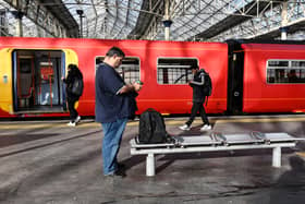 Commuters walk past a train stopped at a platform in Waterloo Station in London, during a national strike day, on February 1, 2023.