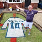 Bryn Nicholls stands next to the Jude Bellingham England shirt mural he has created in his front garden.