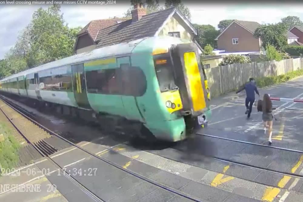Shocking CCTV films the moment a girl risks her life at a level crossing, walking just a couples of metres in front of an advancing train.