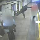Man shoves stranger onto tracks as train arrives at platform.