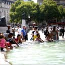 People cool off from the heat at the fountains of Trafalgar square, in central London. (Photo: HENRY NICHOLLS/AFP via Getty Images)