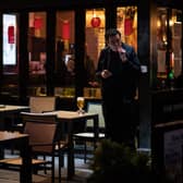 Man smokes a cigarette outside pub.