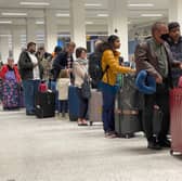 Passengers queue for check in at Manchester Airport's Terminal 1.