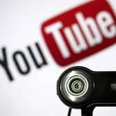 File photo of a camera positioned in front of YouTube's logo. Photo: LIONEL BONAVENTURE/AFP via Getty Images
