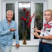 Residents Ian Hunter (L) and Thomas Dunn (R) standing in their hallway next to a vase of flowers.