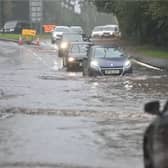 Drivers make their way through flooded roads.