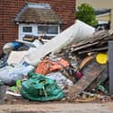 Horrified residents are demanding action after their neighbours turned their home into a makeshift TIP with tonnes of rubbish dumped on the driveway.  