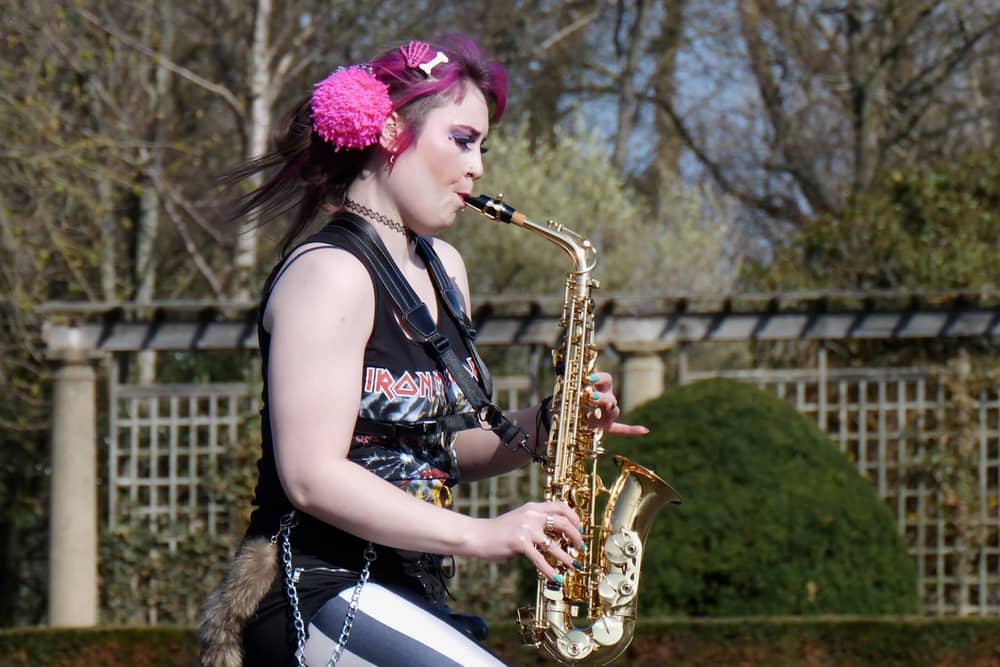 Rachel Ward unicycling while playing the saxophone