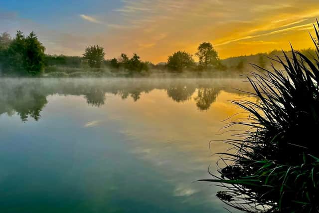 Sunrise over the lake at Brook Meadow, where peaceful mornings can be spent wild swimming in the clear water or casting a line.