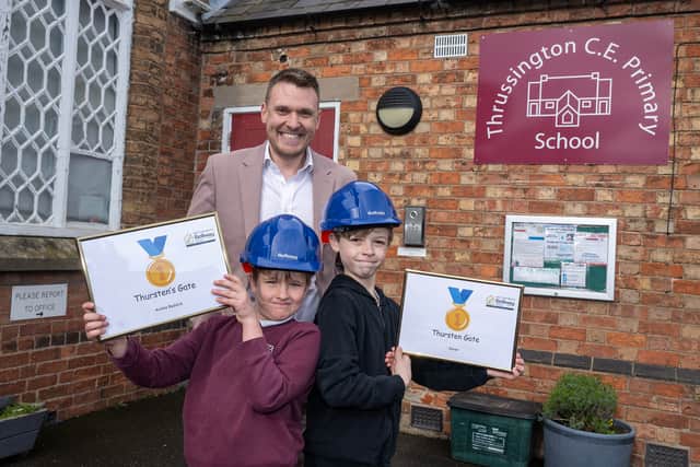 Bellway Senior Sales Manager Adam Champion with the joint winners of the development naming competition at Thrussington CE Primary School