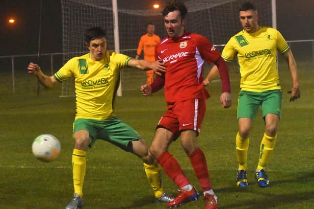 Town goalscorer Zak Munton is shepherded by George Coser and Stan Logan EMN-191218-091338002