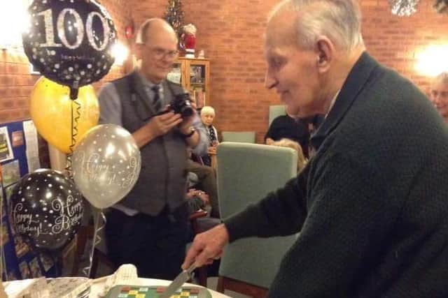Leslie Posnett cuts his Scrabble-themed 100th birthday cake at a party at Gretton Court EMN-200601-185358001