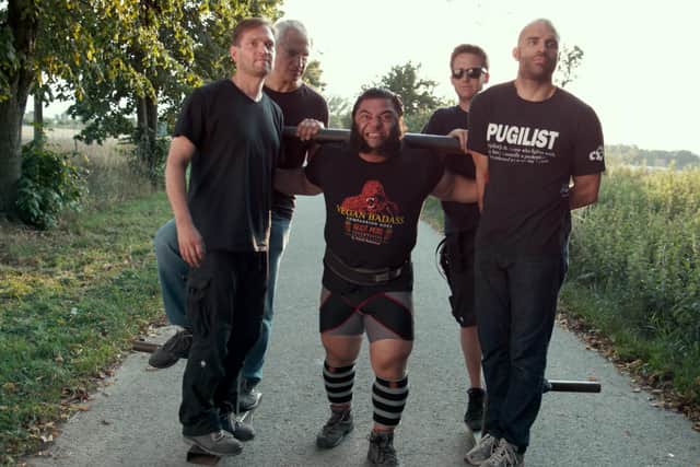 A scene from The Game Changers showing vegan strongman Patrik Baboumian performing one of his remarkable strength feats EMN-200630-133639001