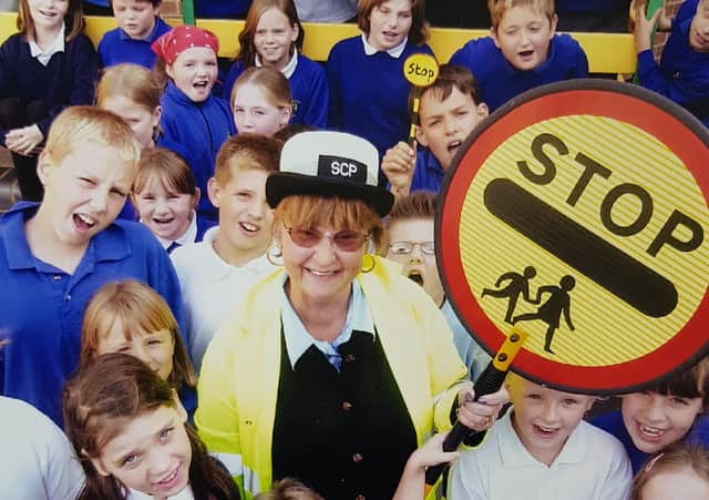 Former Melton lollipop lady, Margaret Hendey, who has passed away aged 78, pictured with The Grove School pupils on her retirement day in 2004 EMN-200109-180557001