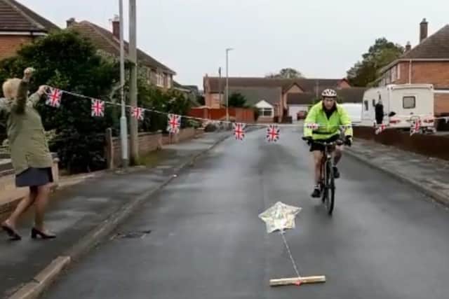 Colin Moulds is welcomed home by fellow Needham Close residents after completing a 300-mile cycle challenge for a cancer charity EMN-200210-160929001