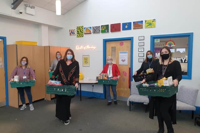 Staff at Melton's Long Field Academy show off some of the food which is being donated to some of the families of students EMN-201117-120404001