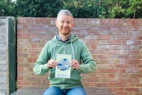 Jeff Brown with a copy of his fundraising travel book EMN-200112-114754001