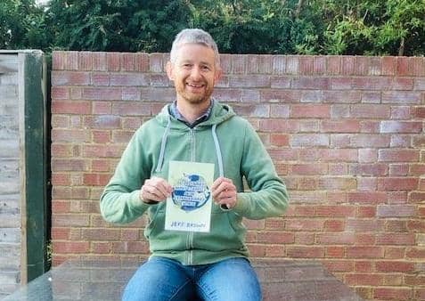 Jeff Brown with a copy of his fundraising travel book EMN-200112-114754001