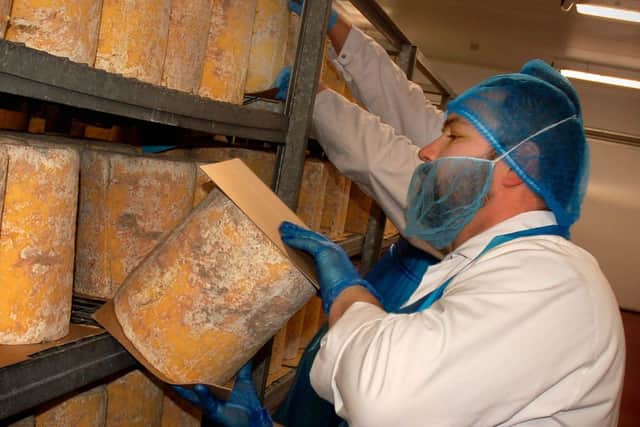 Cheeses are turned daily during the maturation stage at Long Clawson Dairy EMN-200312-160710001