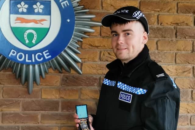 Pc Dan Challis holding a war medal won by his great-great-great grandfather, Pc John William Stephens, aka Pc Tubby EMN-200312-180744001