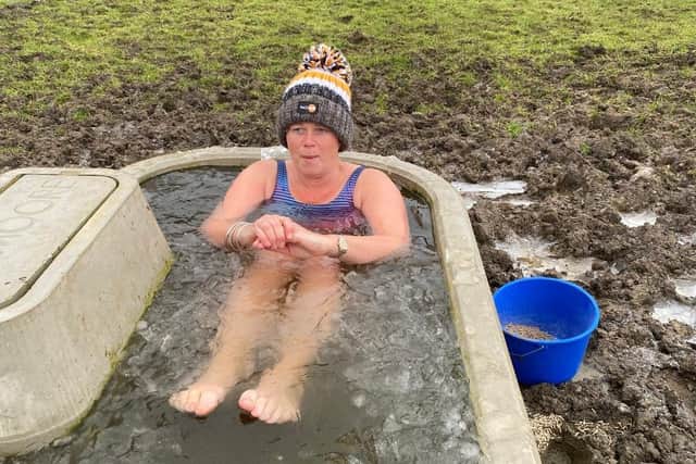 Justine Sore braves near freezing temperatures to complete one of her fundraising dips in an animal water trough at her Melton farm EMN-210114-164350001