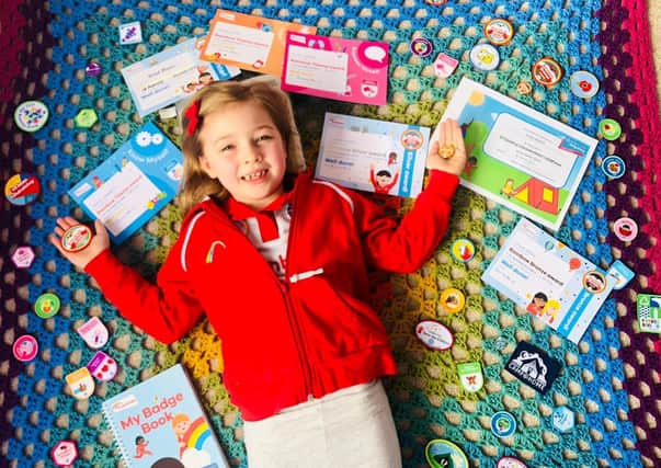 Violet Newell shows off her many badges from Asfordby 1st Rainbows EMN-210215-173006001