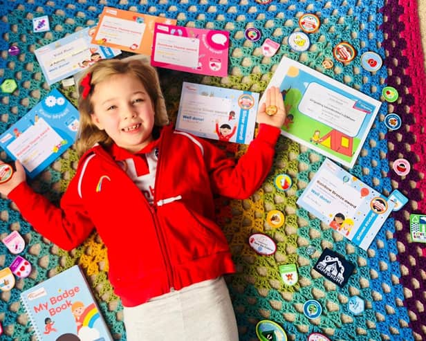 Violet Newell shows off her many badges from Asfordby 1st Rainbows EMN-210215-173006001