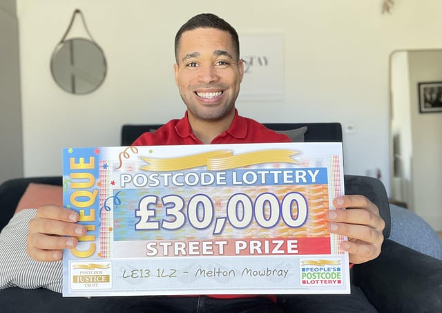 People’s Postcode Lottery ambassador Danyl Johnson with one of the £30,000 cheques won by three Melton residents EMN-210321-170744001