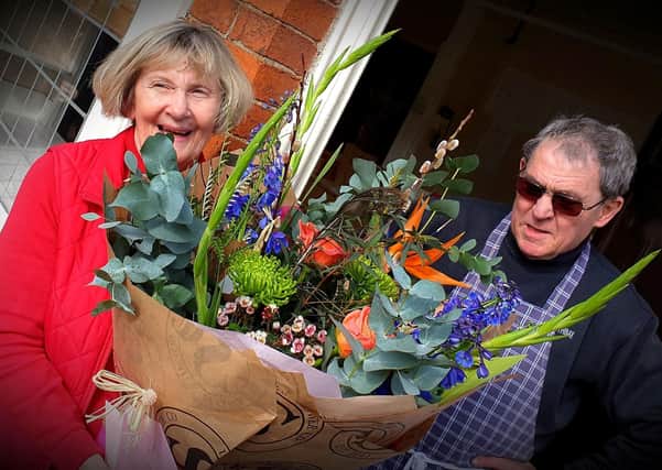 David and Jean Cox with the bouquet they were presented with after retiring from running the butcher's shop at Stathern for 46 years
PHOTO MARTIN FAGAN EMN-201003-132559001