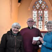 Father Tom McGovern with church members Frances Levett,  Ann Kirby and Sheila Sulley in front of the restored historic stained glass window at Melton's St John's Catholic Church EMN-200318-104403001
