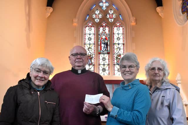Father Tom McGovern with church members Frances Levett, Ann Kirby and Sheila Sulley in front of the restored historic stained glass window at Melton's St John's Catholic Church EMN-200318-104403001