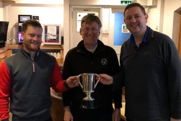 Alex Renwick (left) and Neil Eaves (right) receive the winners trophy from club captain John Harvey EMN-200319-115529002