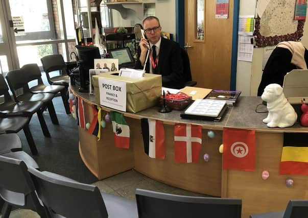 Long Field Academy principal Chris Haggett mans the reception phones today with an appropriate exculsion zone to limit spread of coronavirus EMN-200323-120732001