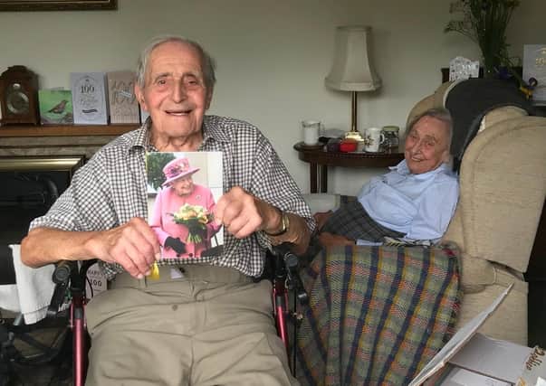 Dennis Kirk celebrates his 100th birthday, holding his birthday card from The Queen, with wife Joan at their Plungar home EMN-200427-175351001