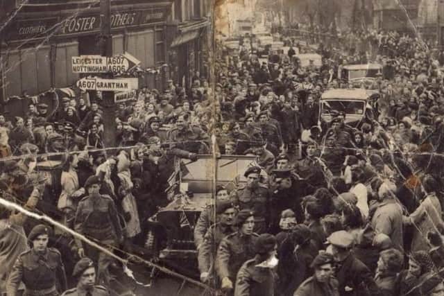 The view down a packed Burton Street, Melton, in 1945 as crowds rejoice at a victory parade to celebrate VE Day at the end of the Second World War EMN-200430-164327001