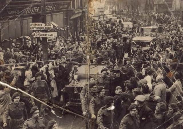 The view down a packed Burton Street, Melton, in 1945 as crowds rejoice at a victory parade to celebrate VE Day at the end of the Second World War EMN-200430-164327001