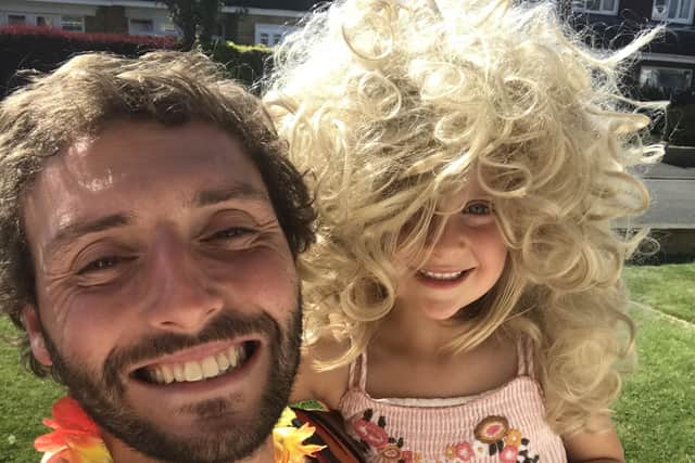 Postman Rob Davenport, who raised £1,500 for the NHS by doing his round in fancy dress, pictured with daughter Peggy, wearing the wig he wore on the round EMN-200526-102753001