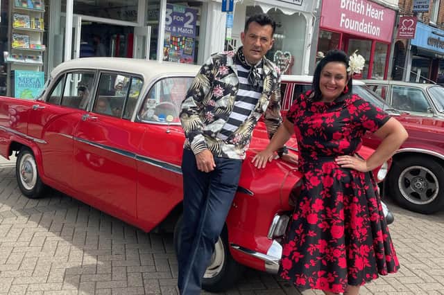Two attendees at July's monthly vintage and craft market in Melton town centre pose by a classic car on display EMN-211028-133438001