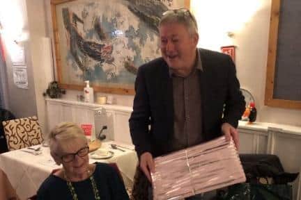 Neil Hunt presents a framed photograph of OGs teams from the late 1970s to Sandra.