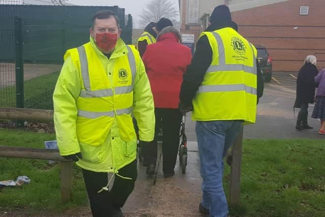 Melton Lions Club volunteers pictured marshalling queues at the town's Covid vaccination centre EMN-211215-083019001