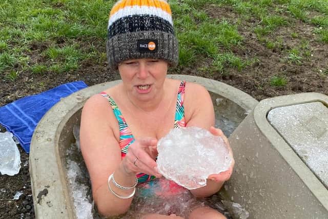 Justine Sore picks the ice out in near freezing temperatures to complete one of her fundraising dips in an animal water trough at her Melton farm EMN-211229-081348001