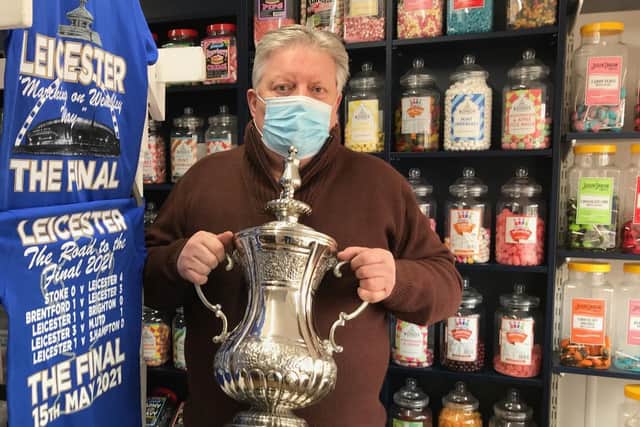 Jamie How, pictured last May showing off a replica FA Cup trophy he was displaying in the window of his Melton shop, How Sweet EMN-220125-100727001