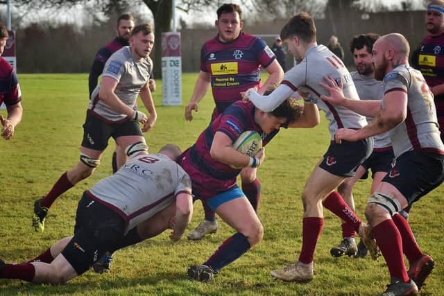 Another tackle from Karl McGee, helped out by Will Garnett and Max Buckley. Photo: Tim Williams