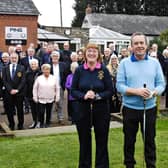 Mick and Joan on the first tee, supported by the members gathered in the background.