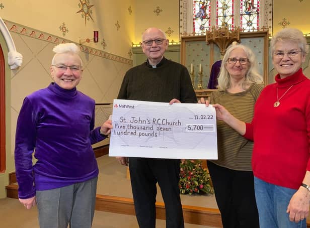 Frances Levett (left) presents a fundraising cheque to Father Tom McGovern for St John's Catholic Church in Melton, with fellow church members Ann Kirby and Sheila Sulley EMN-220213-181203001